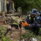 A firefighter from the Lexington Fire Department Search and Rescue team checks on a dog during a targeted search on Highway 476 where three people are still unaccounted for on July 31, 2022 near Jackson, Kentucky.